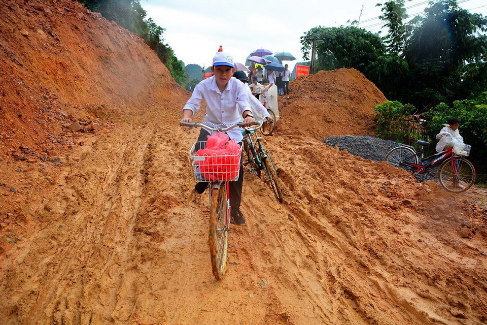 Đoạn đường bị sạt lở gây khó khăn cho các em đến trường. (Ảnh: Phan Tuấn Anh/TTXVN)
