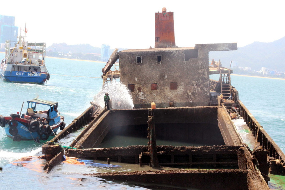 Bơm nước ra khỏi khoang tàu bị chìm để làm nổi tàu. (Ảnh: Nguyên Linh/TTXVN)