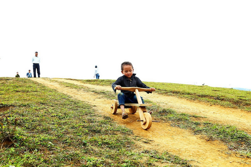 Một đứa trẻ với chiếc xe cút kít trên đỉnh đèo Pha Đin. (Ảnh: Phan Tuấn Anh/TTXVN)