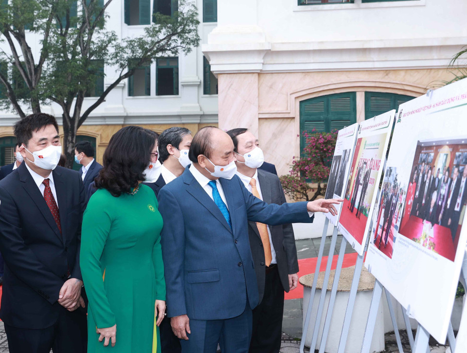 Chủ tịch nước Nguyễn Xuân Phúc xem trưng bày ảnh do Thông tấn xã Việt Nam và Học viện Nông nghiệp Việt Nam phối hợp tổ chức. (Ảnh: Thống Nhất/TTXVN)