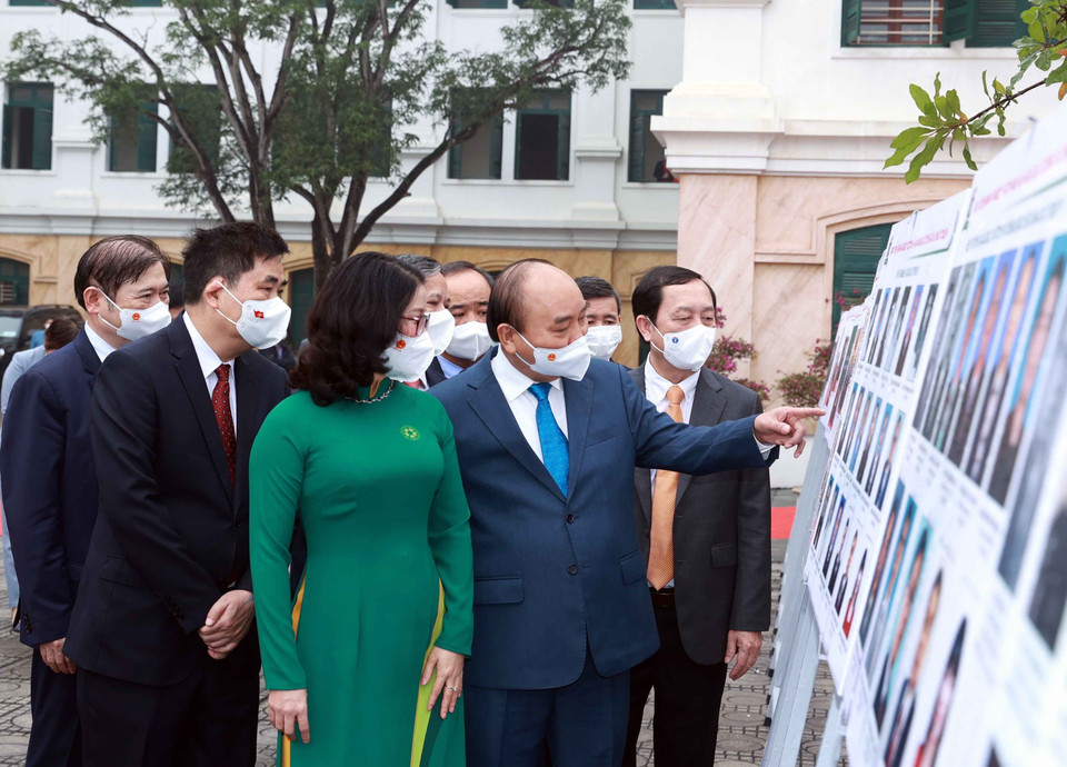 Chủ tịch nước Nguyễn Xuân Phúc xem trưng bày ảnh do Thông tấn xã Việt Nam và Học viện Nông nghiệp Việt Nam phối hợp tổ chức. (Ảnh: Thống Nhất/TTXVN)