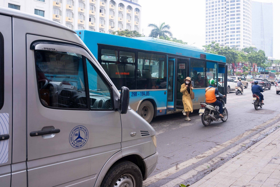Hành khách dễ gặp nguy hiểm khi xe buýt phải dừng ở giữa đường trả khách do vướng các xe khác đỗ chắn điểm vào nhà chờ. (Ảnh: Nguyễn Kế Tùng/TTXVN phát)