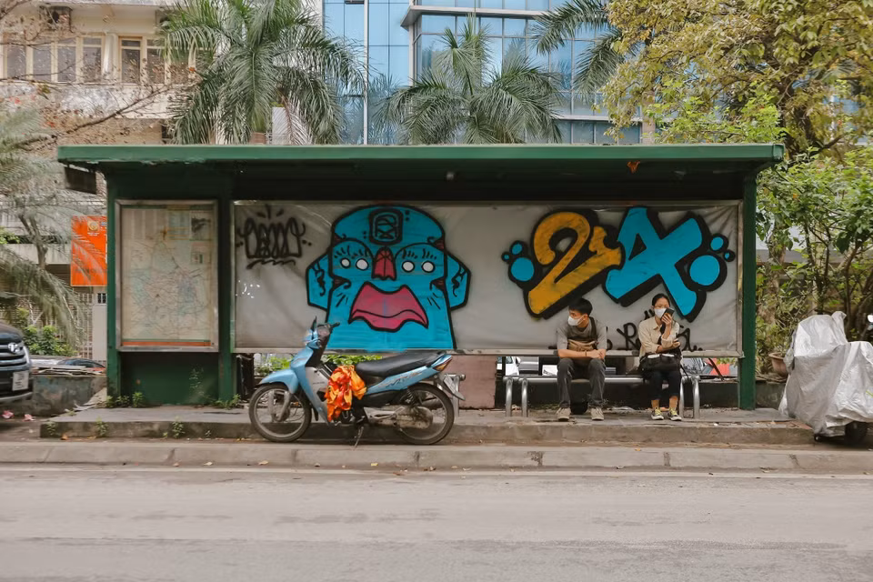 Điểm dừng, nhà chờ xe buýt bị vẽ bậy, xe ôm đỗ chắn lối ra vào của hành khách. (Ảnh: Đoàn Công Vũ/TTXVN phát)