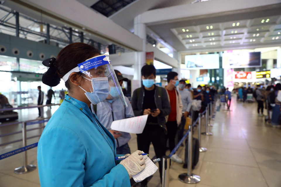 Hầu hết nhân viên sân bay đều đeo đầy đủ khẩu trang, mặt nạ chống giọt bắn để đảm bảo phòng chống dịch. (Ảnh: Huy Hùng/TTXVN)