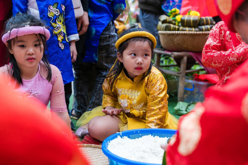  Các em nhỏ trường Mầm non Hoa Sen, thành phố Vinh, rất háo hức, chăm chú, say sưa nhìn người lớn gói bánh chưng xanh trong ngày hội Chào Xuân 2021. (Ảnh: Bích Huệ/TTXVN)