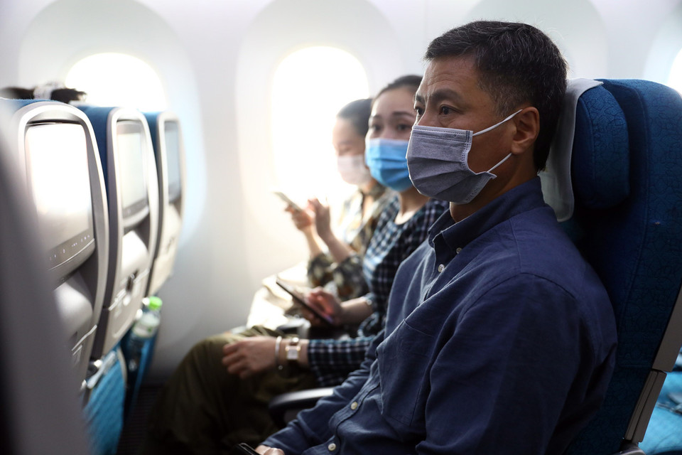 Trên suốt chuyến bay hành khách phải đeo khẩu trang liên tục, đảm bảo tốt công tác phòng chống dịch. (Ảnh: Huy Hùng/TTXVN)