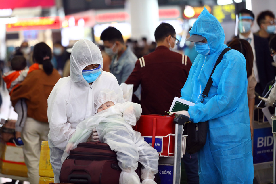 Một gia đình hành khách trang bị đầy đủ bảo hộ phòng chống dịch. (Ảnh: Huy Hùng/TTXVN)