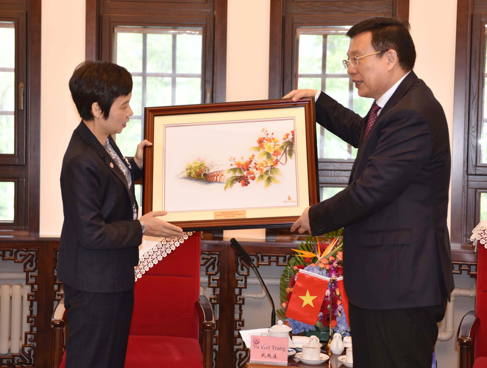 Tổng Giám đốc TTXVN Vũ Việt Trang tặng bức tranh lưu niệm cho Xã trưởng Tân Hoa xã Phó Hoa. (Ảnh: Hải Yến/TTXVN)