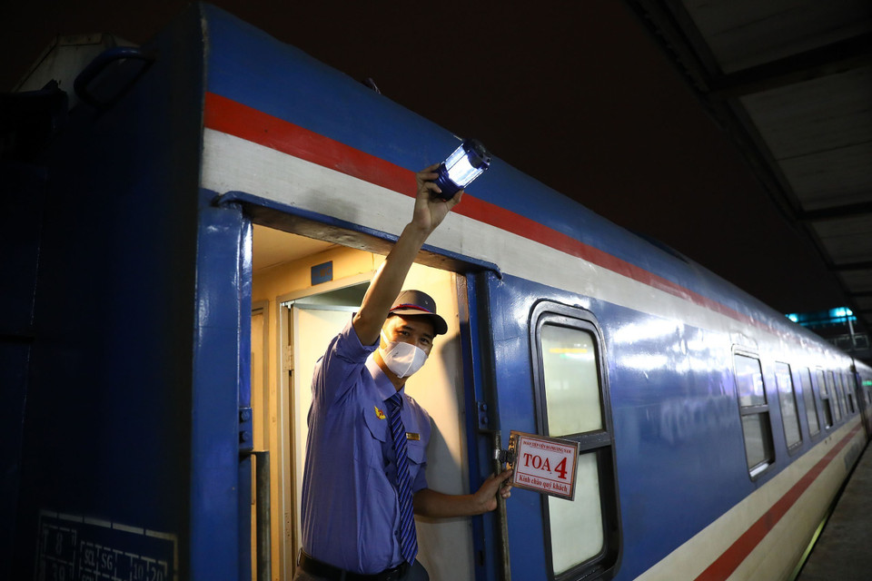 Nhân viên đường sắt hiệu lệnh tàu bắt đầu lăn bánh. (Ảnh: Huy Hùng/TTXVN)