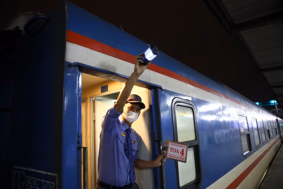 Nhân viên đường sắt hiệu lệnh tàu bắt đầu lăn bánh. (Ảnh: Huy Hùng/TTXVN)