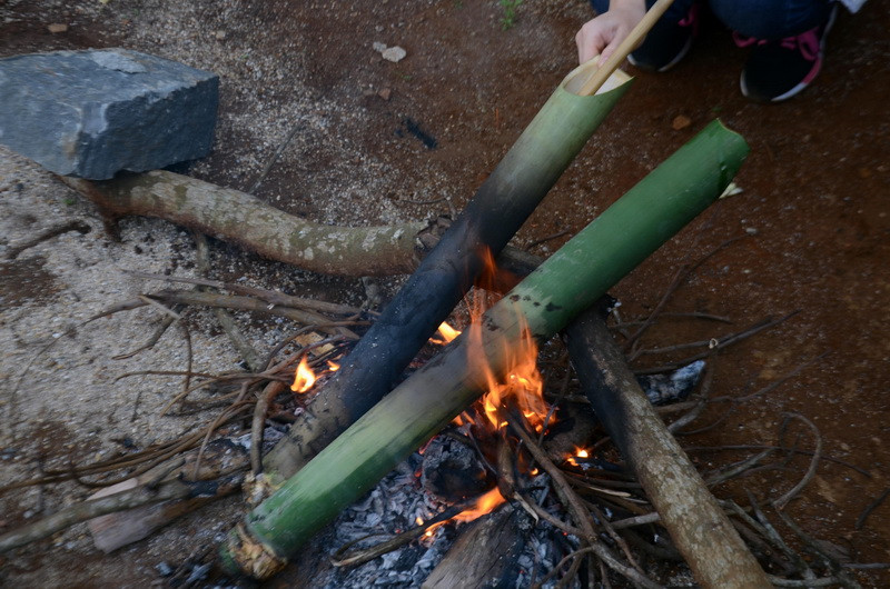 Sau đó, người nấu sẽ dùng một ống tre thụt tới thụt lui cho đến khi canh trong ống nhuyễn nhừ. (Ảnh: Hưng Thịnh/TTXVN)