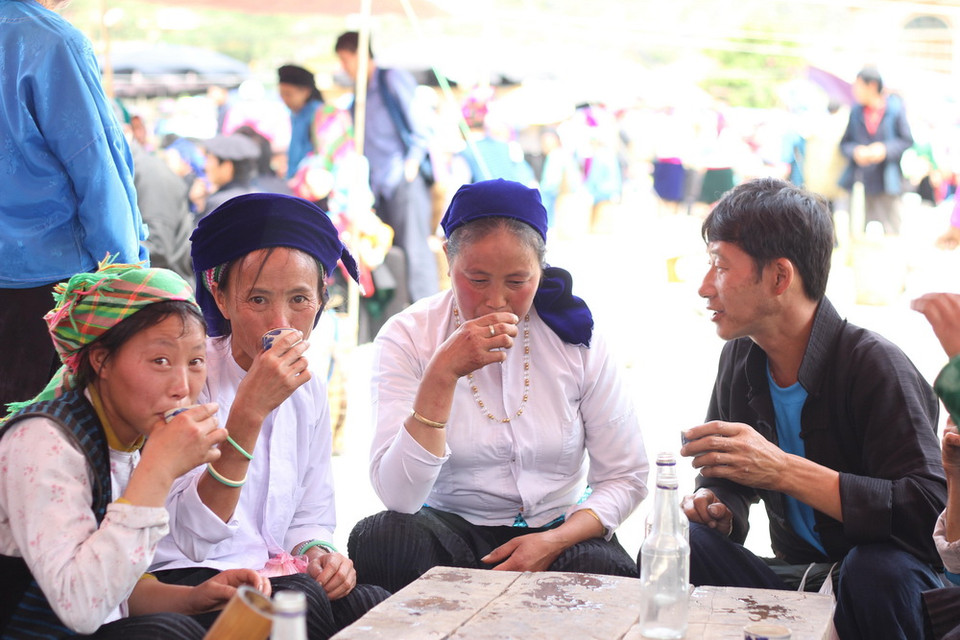 Người H'Mông đi chợ phiên không thể không nhấp chén rượu nồng. (Ảnh: Đỗ Bình/TTXVN)