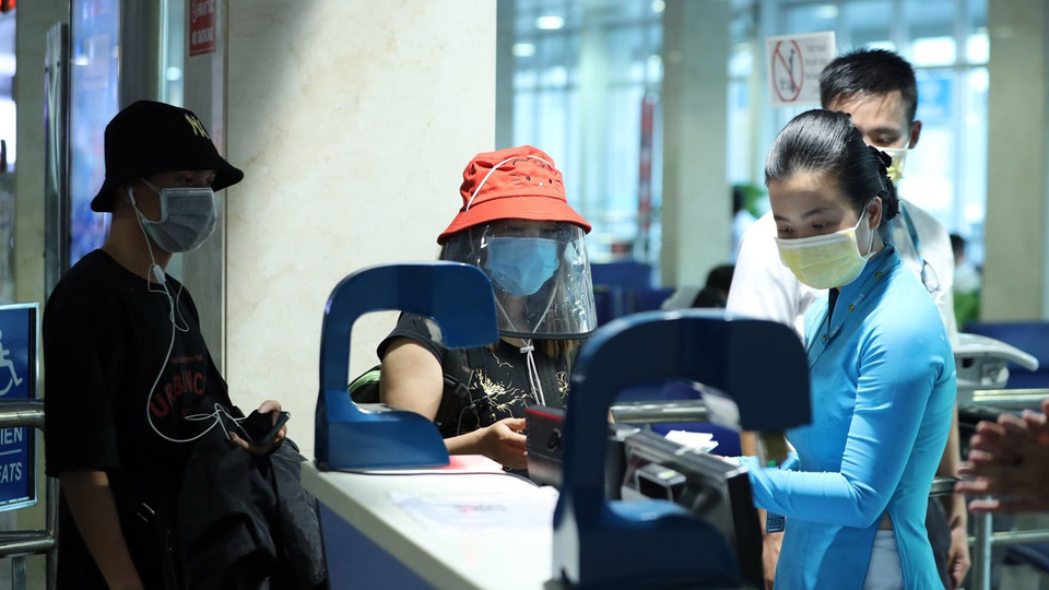 Hành khách tuân thủ đeo khẩu trang tại sân bay Nội Bài. (Ảnh: CTV/Vietnam+)