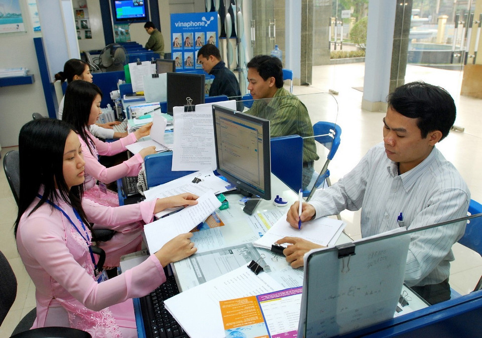Nhân viên VinaPhone hướng dẫn khách hàng sử dụng dịch vụ. (Ảnh: TTXVN)