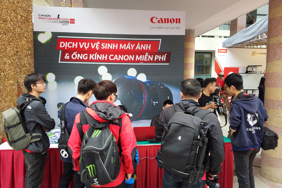 Các thí sinh tranh thủ vệ sinh máy ảnh, ống kính Canon miễn phí tại cuộc thi. (Ảnh: T.H/Vietnam+)