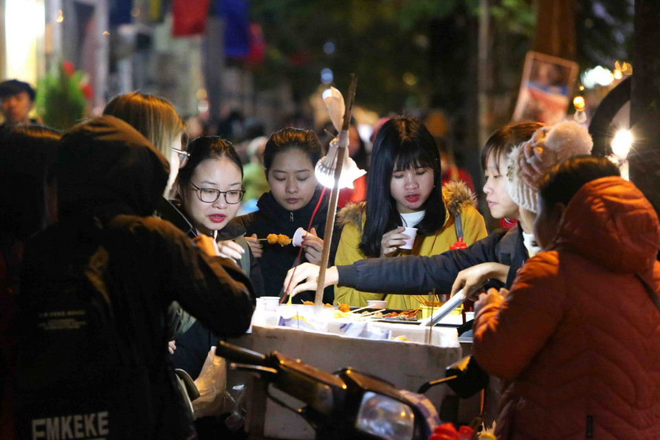 Các em học sinh chọn những món ăn cay nóng để giữ ấm cơ thể. (Ảnh: Thành Đạt/TTXVN)