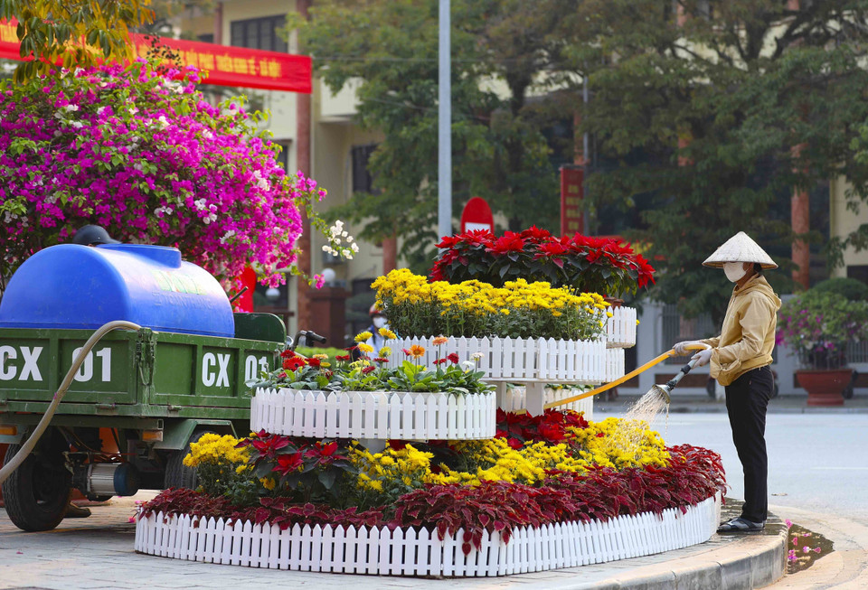 Chăm sóc những bồn hoa tươi trang trí tại nhiều vị trí trên đường Võ Nguyên Giáp, thành phố Điện Biên Phủ. (Ảnh: Xuân Tư/TTXVN)