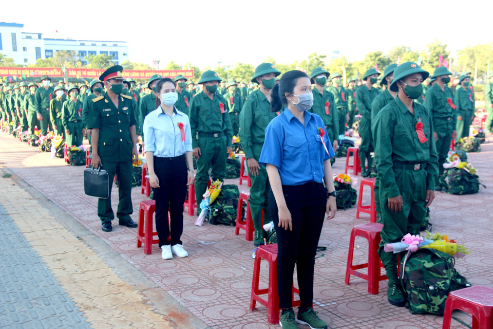 Hai chiến sỹ nữ bên cạnh các tân binh nam nhập ngũ vào quân đội. (Ảnh: Nguyễn Thanh/TTXVN)