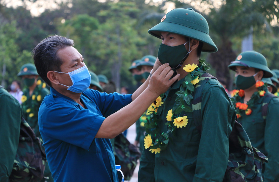 Đeo khẩu trang cho các tân binh ở Đồng Tháp lên đường nhập ngũ. (Ảnh: Chương Đài/TTXVN)