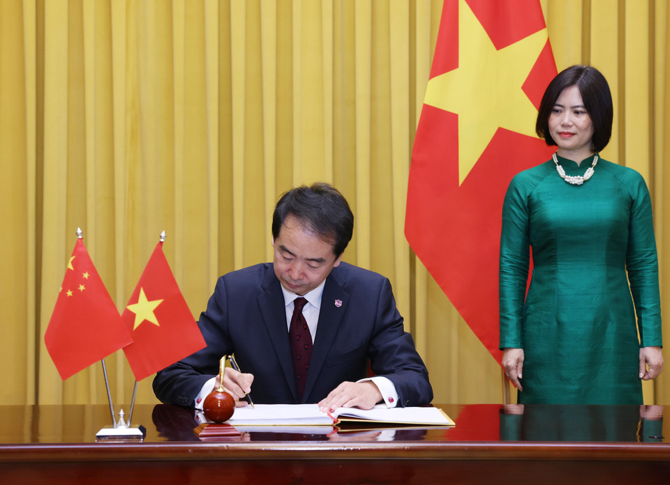 Đại sứ Trung Quốc tại Việt Nam Hà Vĩ ghi lưu bút. (Ảnh: Lâm Khánh/TTXVN)