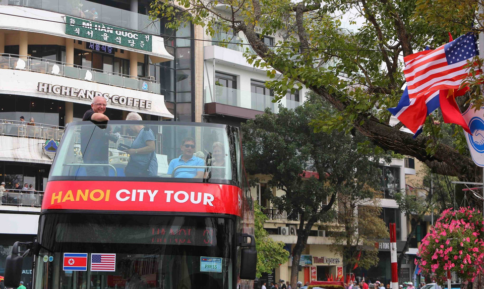 Khách du lịch nước ngoài thích thú với dịch vụ xe bus 2 tầng quanh Hà Nội. (Ảnh: Thành Đạt/TTXVN)