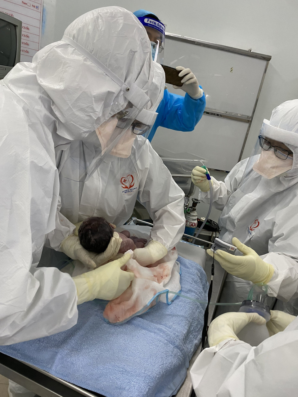 Bác sỹ 3 bệnh viện: Bệnh viện Hồi sức COVID-19, Bệnh viện Trưng Vương và Bệnh viện Nhi đồng Thành phố mổ lấy thai thành công cho thai phụ mắc COVID-19. (Ảnh: TTXVN phát)