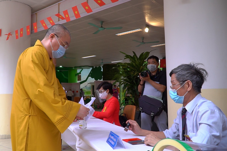 Các cử tri đến điểm bầu cử đều phải khai báo y tế cũng như tuân thủ các biện pháp sát khuẩn, đo y tế trước khi vào bên trong. (Ảnh: Minh Hiếu/Vietnam+) 