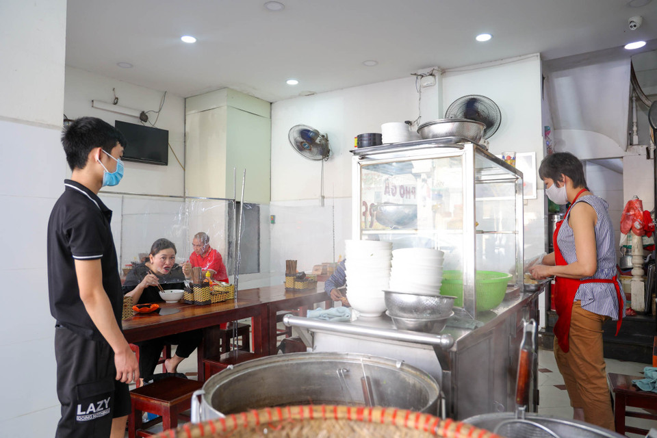 Ngoài các quán càphê, nhiều quán ăn vỉa hè cũng tuân thủ việc đóng cửa phòng dịch. Với những quán ăn trong nhà, chủ quán đã bố trí đầy đủ các chai nước rửa tay sát khuẩn và vệ sinh sạch sẽ hàng quán, giãn cách khách ngồi. (Ảnh: Minh Hiếu/Vietnam+)