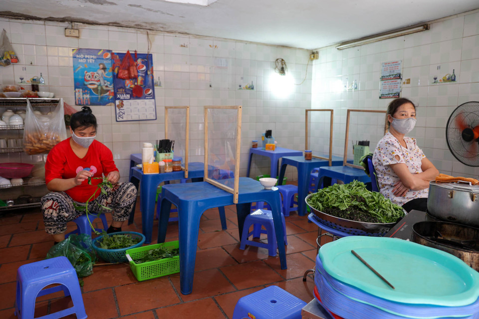 Chủ quán lòng chần cháo phố Đào Duy Từ cho biết cửa hàng đã cấp tốc lắp màn ngăn cho các thực khách ngồi ngay khi thành phố ra quyết định để đảm bảo an toàn. (Ảnh: Minh Hiếu/Vietnam+)