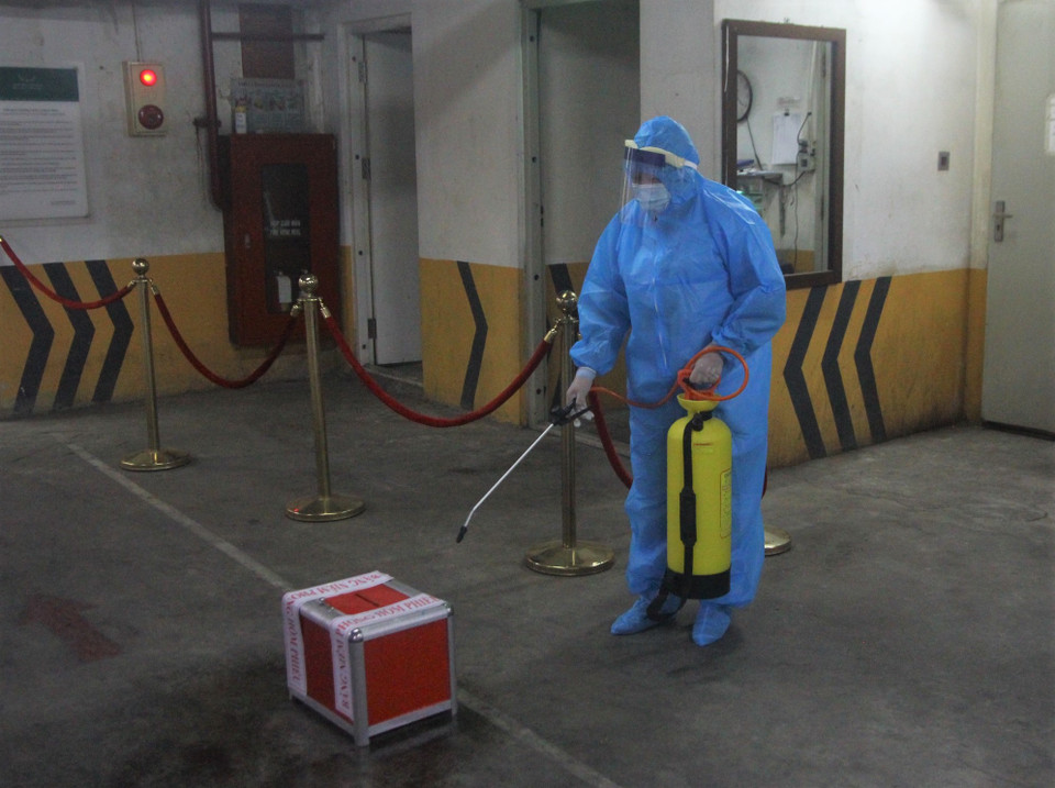 Để có thể vào khu cách ly, các cán bộ thuộc tổ bầu cử phải thực hiện đủ quy trình sát khuẩn và đảm bảo an toàn phòng chống dịch COVID-19 với việc mặc đồ bảo hộ, sát khẩu từng dụng cụ đem theo. Hòm phiếu phụ cũng được sát khuẩn. (Ảnh: PV/Vietnam+)