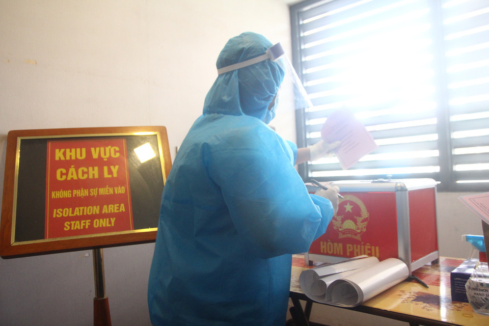 Công tác bầu cử trong điểm cách ly diễn ra nhanh gọn. Từng người sẽ thực hiện nghĩa vụ và giữ khoảng cách an toàn với cán bộ tổ bầu cử. (Ảnh: PV/Vietnam+)