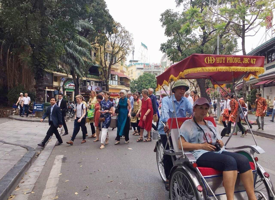 Du khách nước ngoài tham quan, ngắm cảnh khu vực hồ Hoàn Kiếm trong dịp diễn ra Hội nghị thượng đỉnh Mỹ-Triều Tiên lần thứ hai, cuối tháng 2/2019. (Ảnh: Diệu Anh/TTXVN)