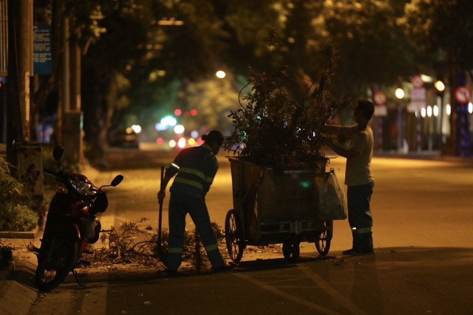 Đêm đêm, trên những con phố vắng lặng vẫn luôn có những người cần mẫn làm sạch phố phường. (Ảnh: Minh Quyết/TTXVN)