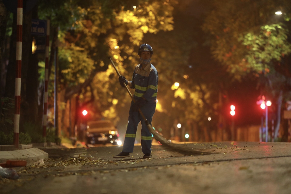 Đêm xuống là lúc những công nhân môi trường cần mẫn, âm thầm làm việc. (Ảnh: Minh Quyết/TTXVN)