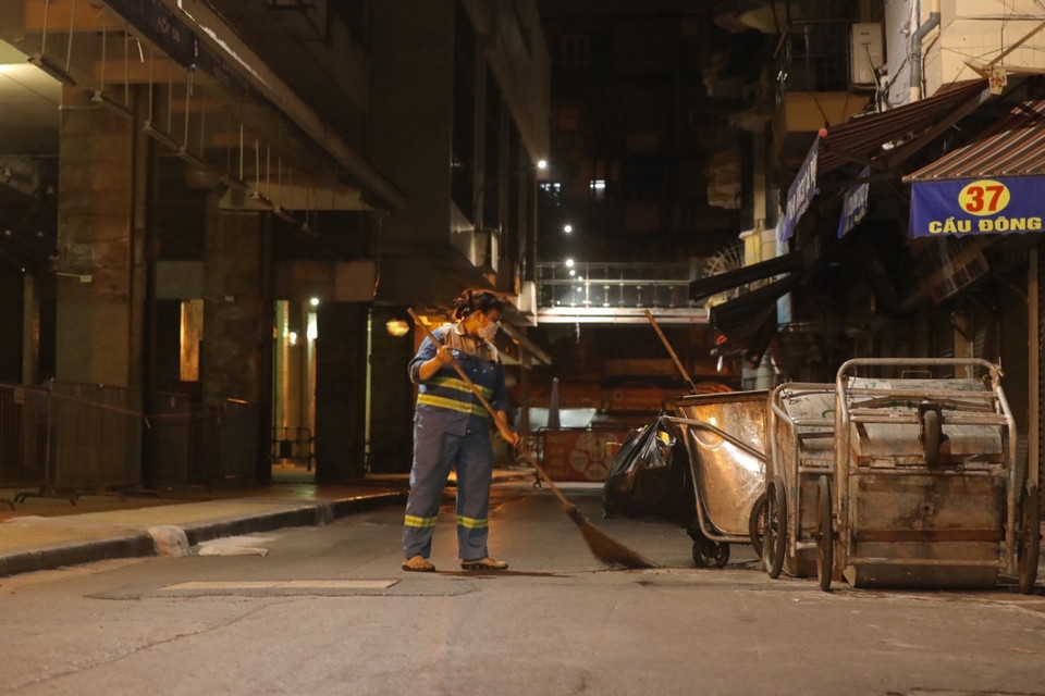 Còn biết bao nguy cơ tiềm ẩn trong bóng đêm, ảnh hưởng đến công việc của một người công nhân môi trường. (Ảnh: Minh Quyết/TTXVN)