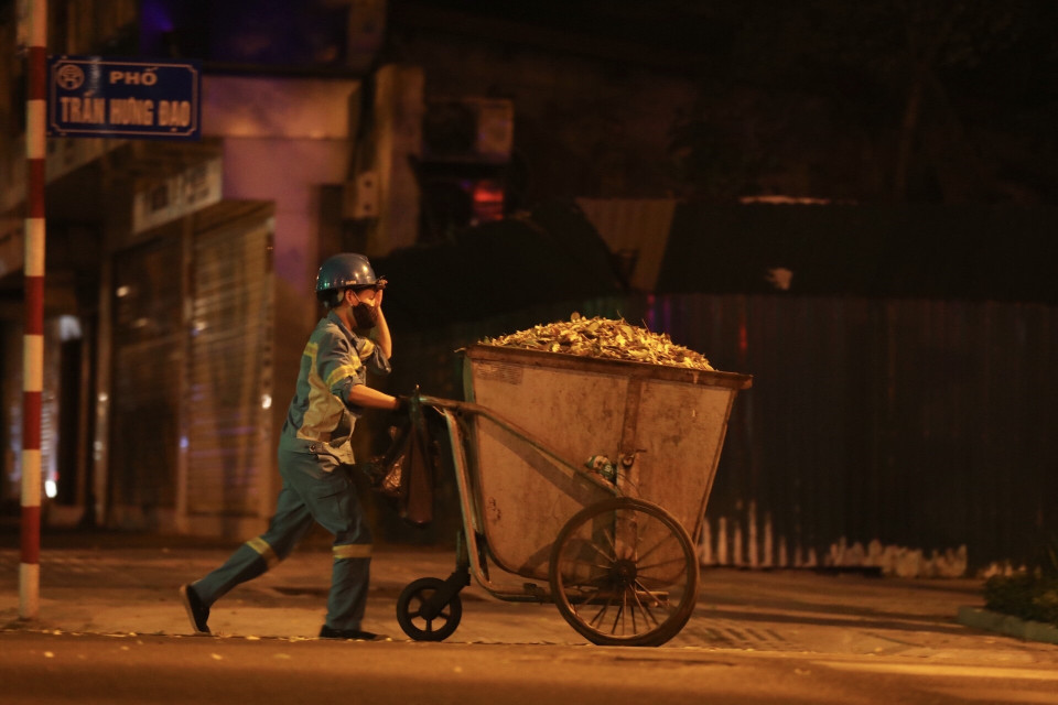 Trên những con phố vắng lặng, có những con người cần mẫn làm sạch phố phường. (Ảnh: Minh Quyết/TTXVN)