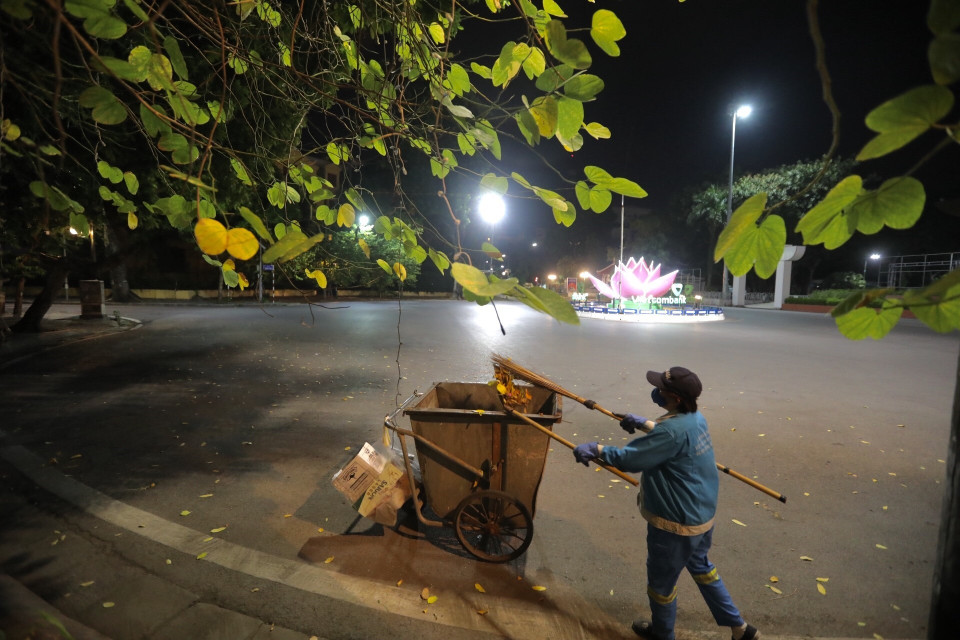 Người lao công thầm lặng gìn giữ vệ sinh đường phố. (Ảnh: Minh Quyết/TTXVN)