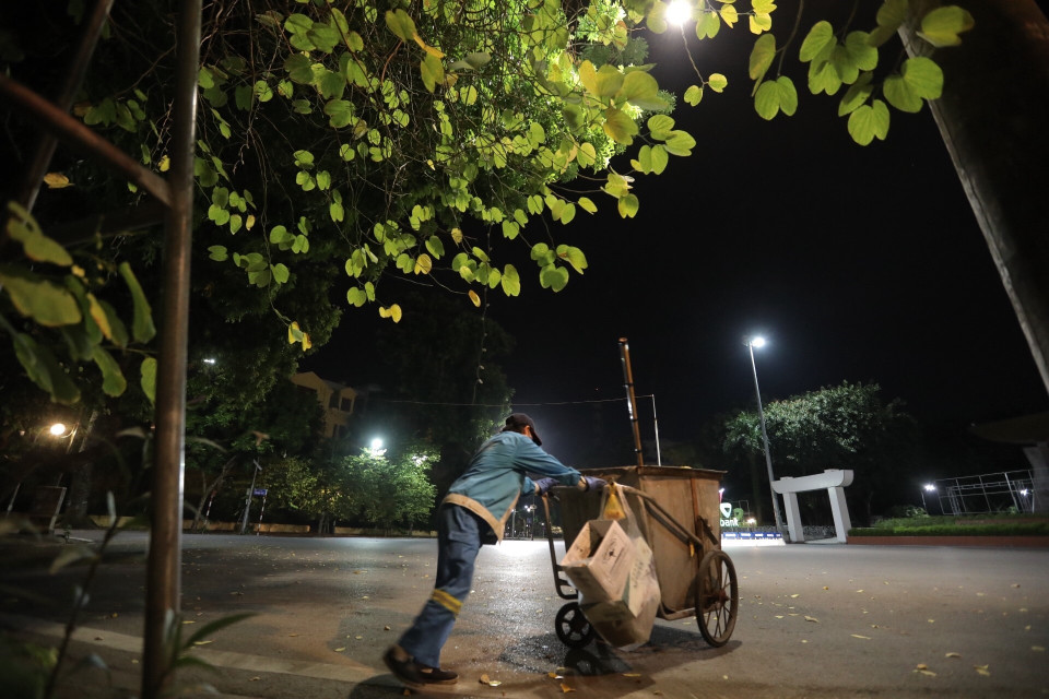 Người lao công thầm lặng gìn giữ vệ sinh đường phố. (Ảnh: Minh Quyết/TTXVN)