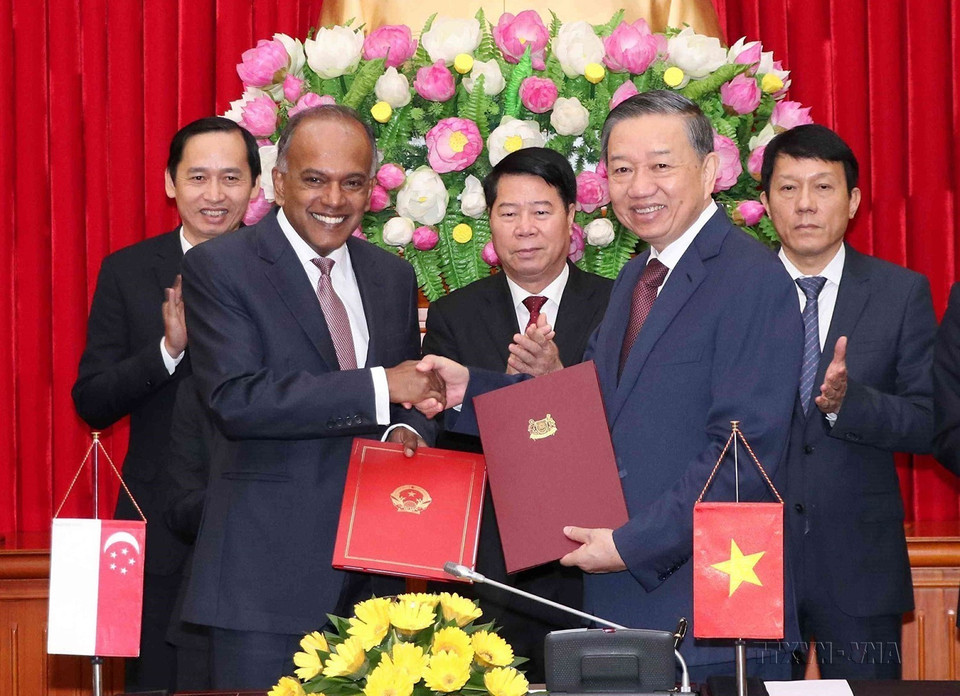 Bộ trưởng Công an Tô Lâm và Bộ trưởng Nội vụ kiêm Bộ trưởng Bộ Pháp luật Singapore K. Shanmugam ký văn kiện gia hạn thỏa thuận hợp tác song phương trong lĩnh vực phòng, chống tội phạm xuyên quốc gia tại Hà Nội ngày 6/12/2018. (Ảnh: Văn Điệp/TTXVN)