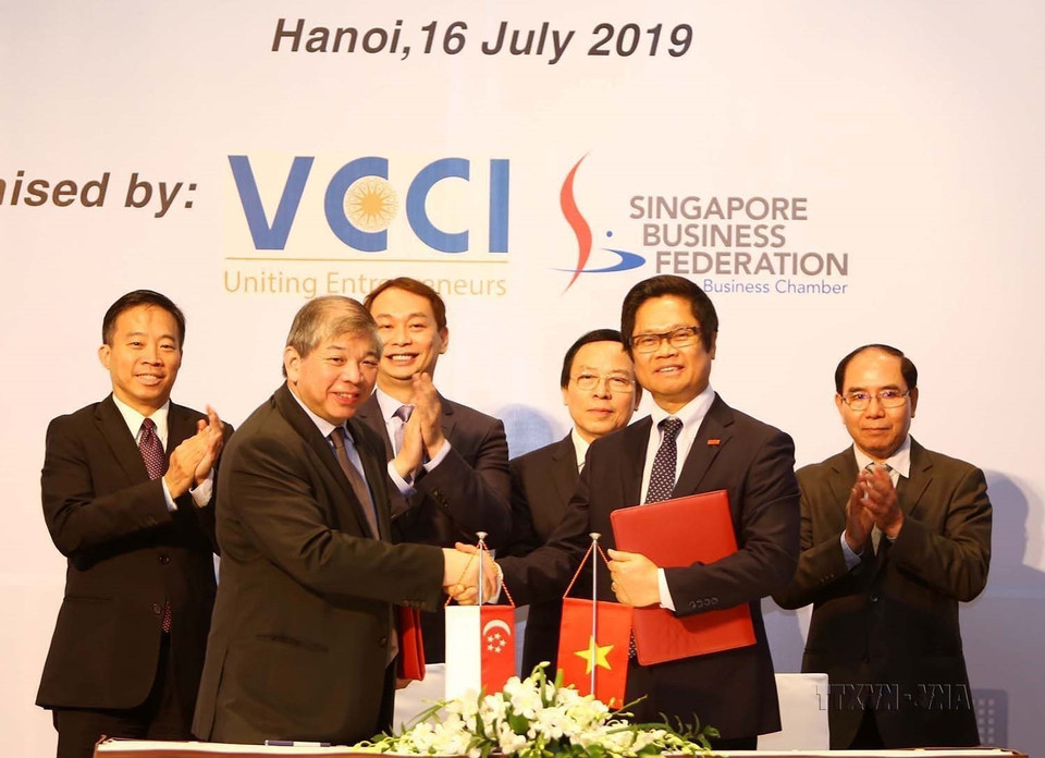 Chủ tịch Phòng Thương mại công nghiệp Việt Nam (VCCI) Vũ Tiến Lộc (phải) và Chủ tịch Liên đoàn doanh nghiệp Singapore (SBF) Teo Siong Seng ký kết thỏa thuận hợp tác tại Hà Nội ngày 16/7/2019). (Ảnh: Nhật Anh/TTXVN)