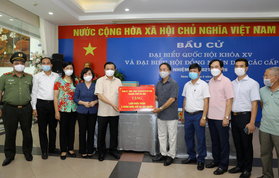 Bí thư Thành ủy Hà Nội Đinh Tiến Dũng trao quà hỗ trợ phòng, chống dịch bệnh COVID-19 tại Khu vực bỏ phiếu số 8, phường Phú Thượng, quận Tây Hồ, Hà Nội. (Ảnh: Nguyễn Điệp/TTXVN)