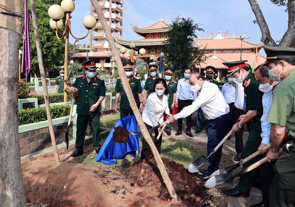 Chủ tịch nước Nguyễn Xuân Phúc trồng cây lưu niệm tại Đền Tưởng niệm Liệt sỹ Bến Dược. (Ảnh: Thống Nhất/TTXVN)