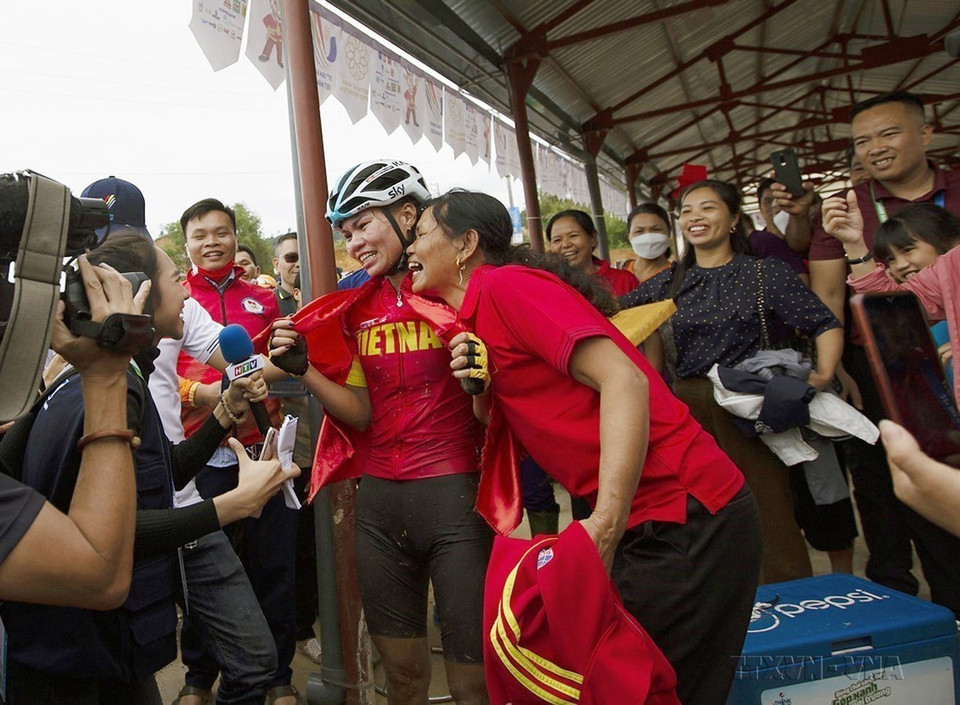 Khoảnh khắc hạnh phúc của hai mẹ con vận động viên dân tộc Mường Đinh Thị Như Quỳnh khi cô về đích đầu tiên và đoạt huy chương Vàng nội dung thi đấu Xe đạp Băng đồng Olympic nữ cho đội tuyển xe đạp địa hình Việt Nam ngay trên quê hương mình. (Ảnh: Trọng Đạt/TTXVN)