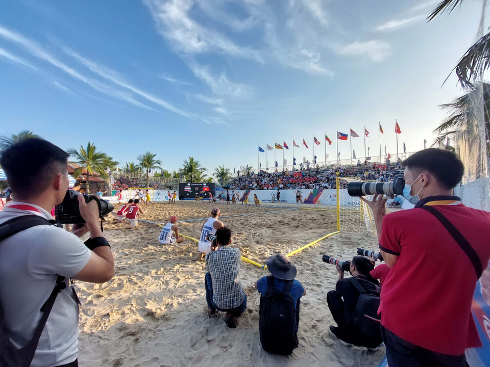 Các phóng viên ảnh tác nghiệp trận bóng ném bãi biển nam tại bãi biển Tuần Châu, Hạ Long. (Ảnh: Thanh Vân/TTXVN)