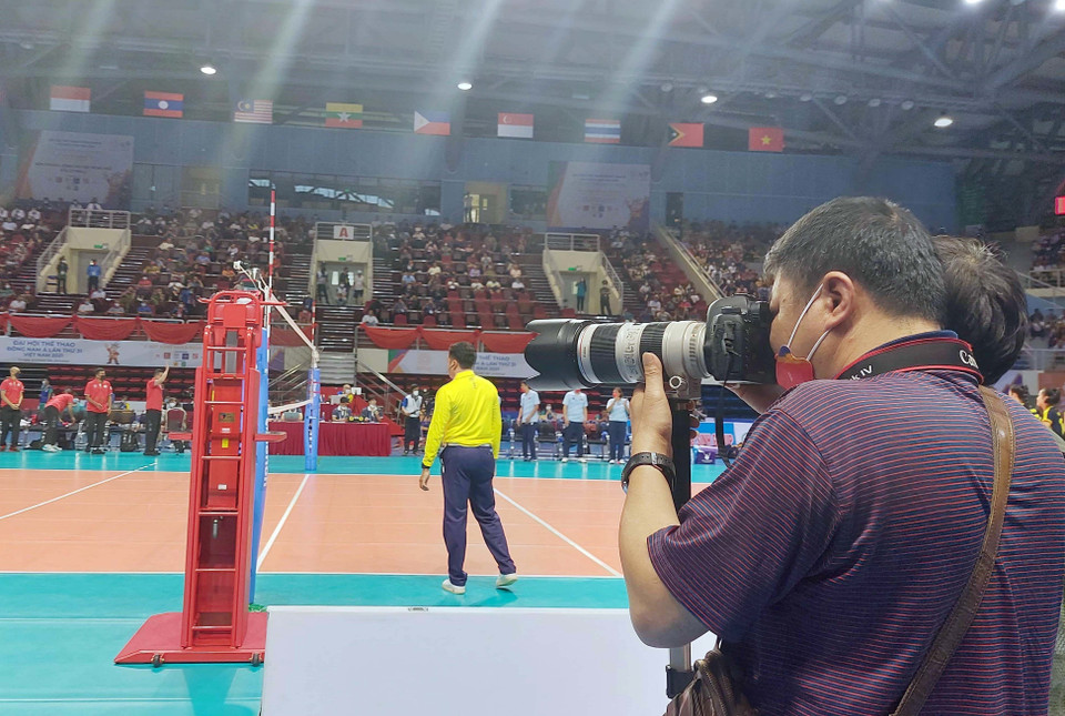 Phóng viên TTXVN tác nghiệp trong trận thi đấu bóng chuyền nữ trong nhà giữa Việt Nam gặp Thái Lan. (Ảnh: Đức Hiếu/TTXVN)