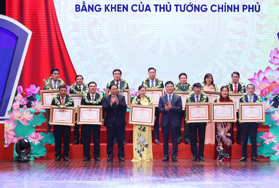 Thủ tướng Phạm Minh Chính và Bộ trưởng Bộ Tư pháp Lê Thành Long trao Bằng khen cho các tập thể và cá nhân tiêu biểu. (Ảnh: Dương Giang/TTXVN)