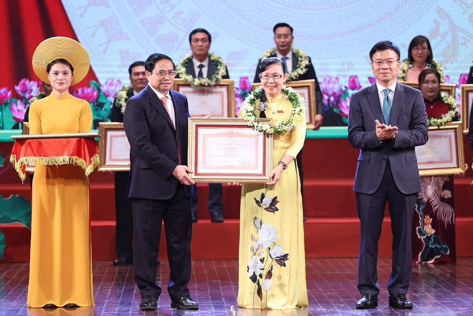Thủ tướng Phạm Minh Chính và Bộ trưởng Bộ Tư pháp Lê Thành Long trao Bằng khen cho các cá nhân tiêu biểu. (Ảnh: Dương Giang/TTXVN)