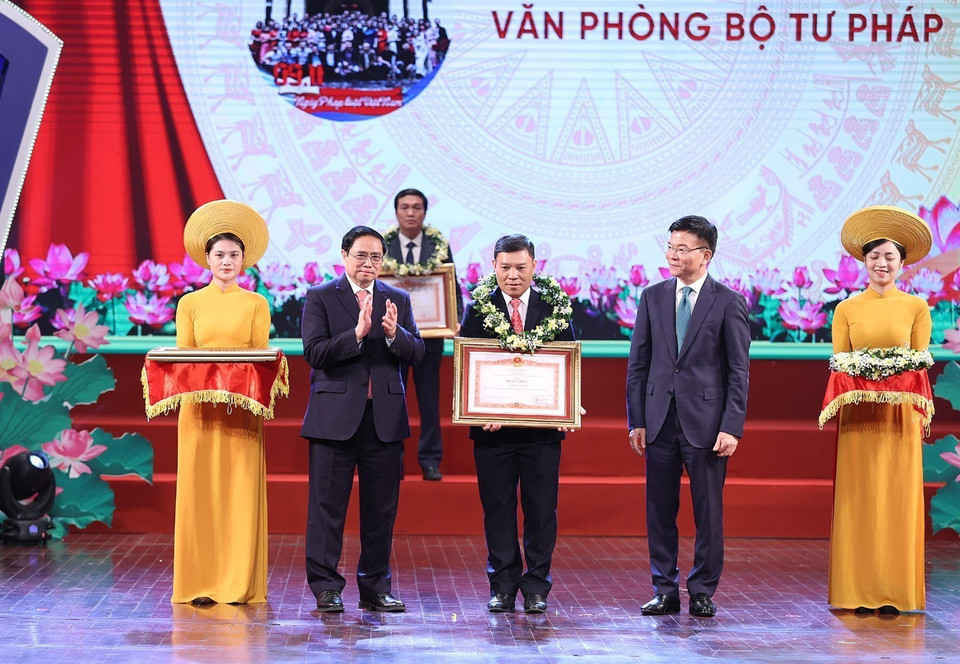 Thủ tướng Phạm Minh Chính và Bộ trưởng Bộ Tư pháp Lê Thành Long trao Bằng khen cho các tập thể tiêu biểu. (Ảnh: Dương Giang/TTXVN)