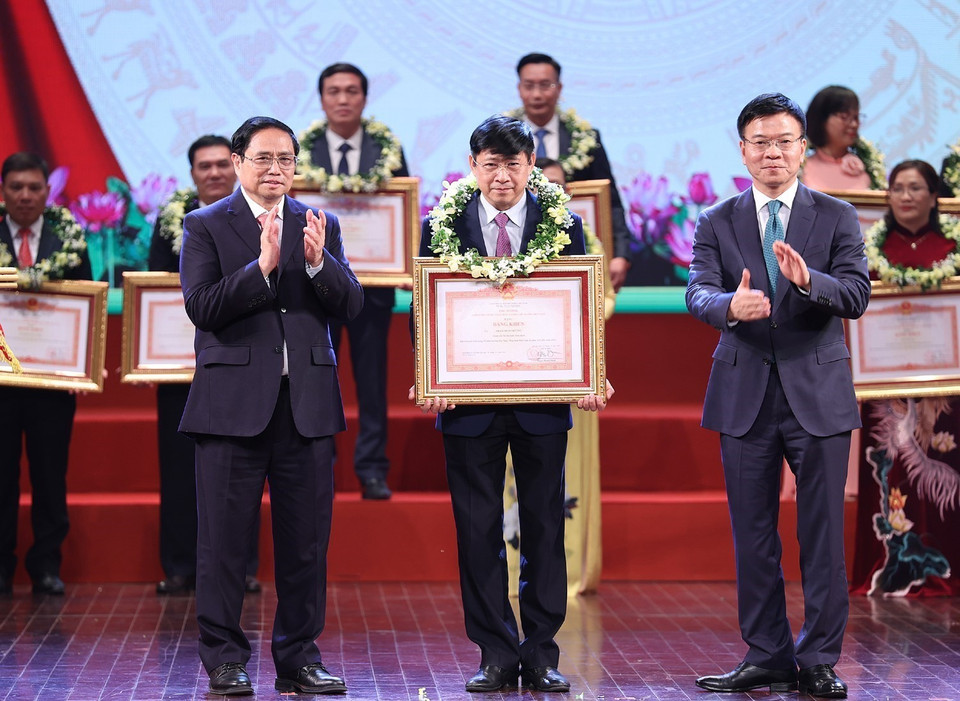 Thủ tướng Phạm Minh Chính và Bộ trưởng Bộ Tư pháp Lê Thành Long trao Bằng khen cho các cá nhân tiêu biểu. (Ảnh: Dương Giang/TTXVN)