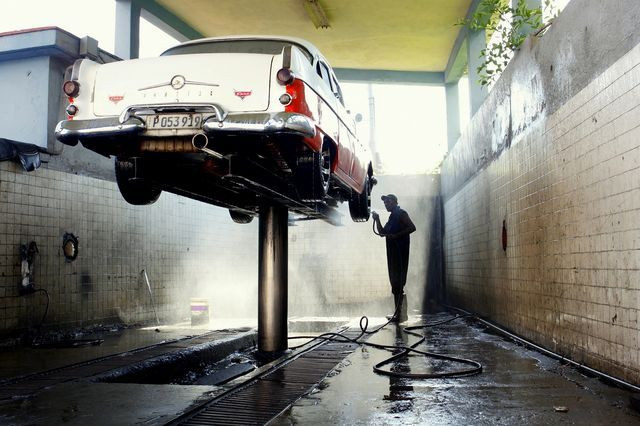 Một công nhân rửa chiếc xe hơi cổ điển ở Havana, Cuba. (Nguồn: National Geographic)